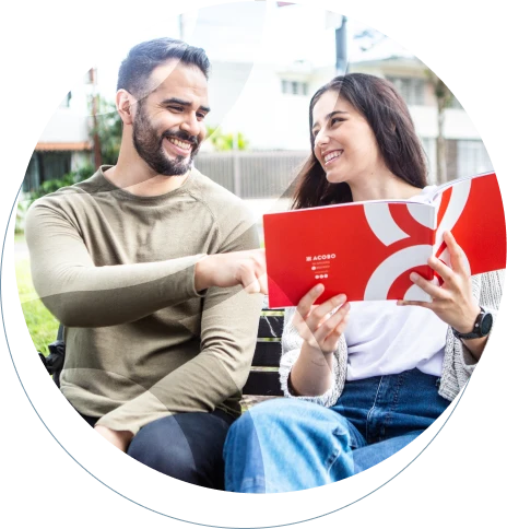 Un hombre y una mujer viendo un folder con la información de la empresa ACOBO